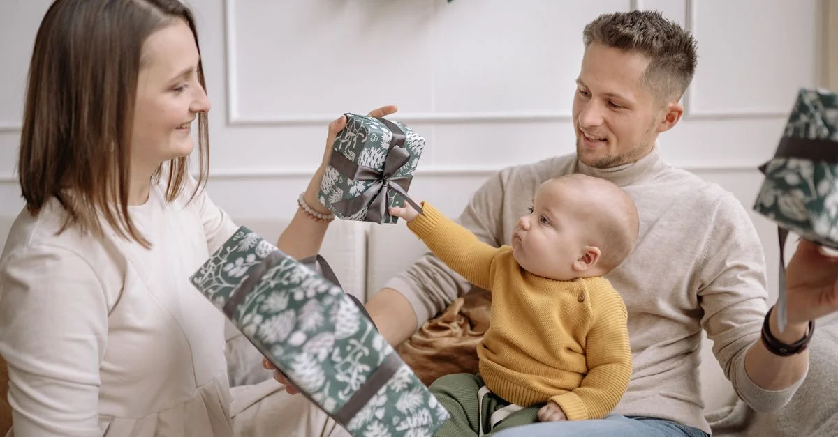 Une famille joyeuse échangeant des cadeaux de Noël tout en se liant à l'intérieur.