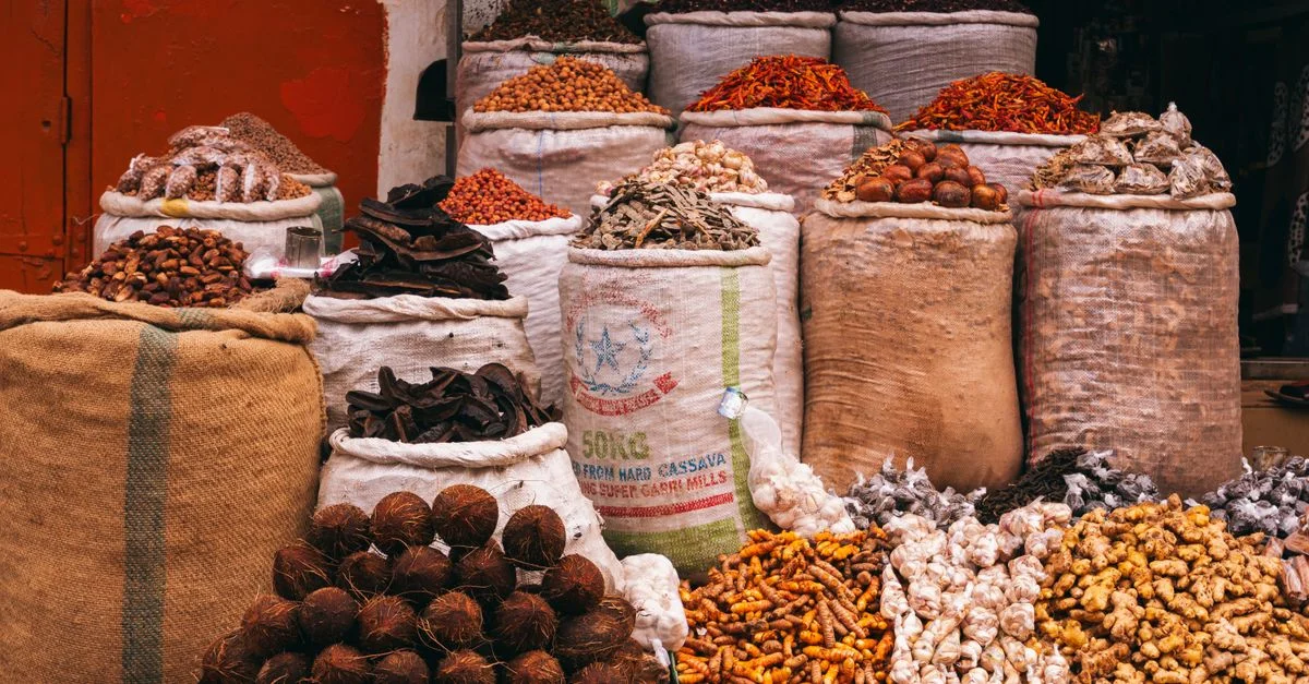 Variété colorée d'épices et d'herbes exposées dans un marché animé de Jos, au Nigéria.