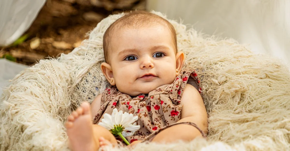 Portrait charmant d'une fille bébé allongée dans un panier avec une fleur, profitant d'une journée ensoleillée à l'extérieur.